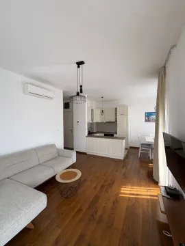 Living room with a sofa and dining area in an open plan layout. - image 2