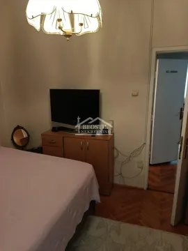 Spavaća soba sa krevetom, komodom i televizorom. - image 4