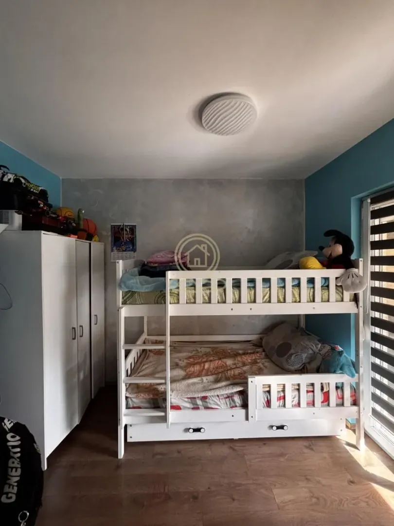 Children's bedroom with a bunk bed and a white wardrobe.