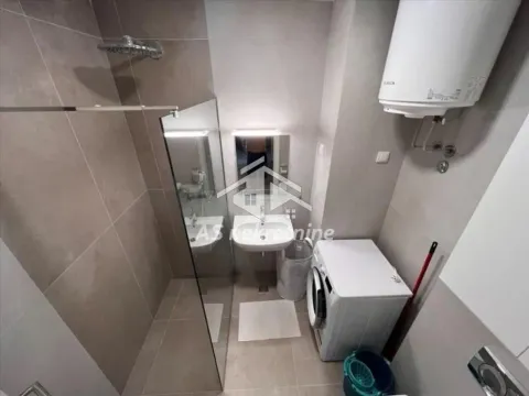 Modern bathroom with a walk-in shower, washbasin, and washing machine. - image 11