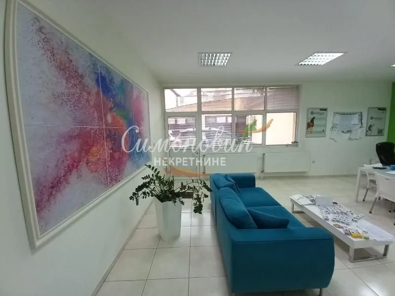Living room with a blue sofa and a large art piece on the wall.
