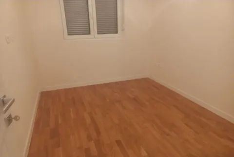 Empty room with light walls and wooden flooring. - image 2