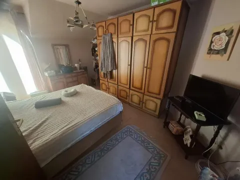Nameštena spavaća soba sa bračnim krevetom, velikim drvenim ormarom i televizorom. - image 20