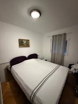 Spavaća soba sa bračnim krevetom, prozorom i umjetničkom slikom na zidu. - image 5