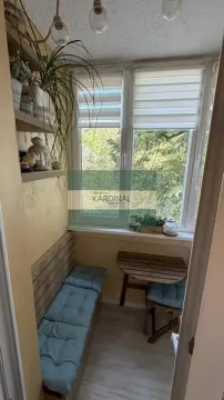 Zastakljeni balkon sa klupom, drvenim stočićem i pogledom na zelenilo. - image 6
