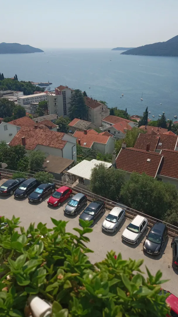 Pogled na more i okolne kuće sa terase nekretnine.