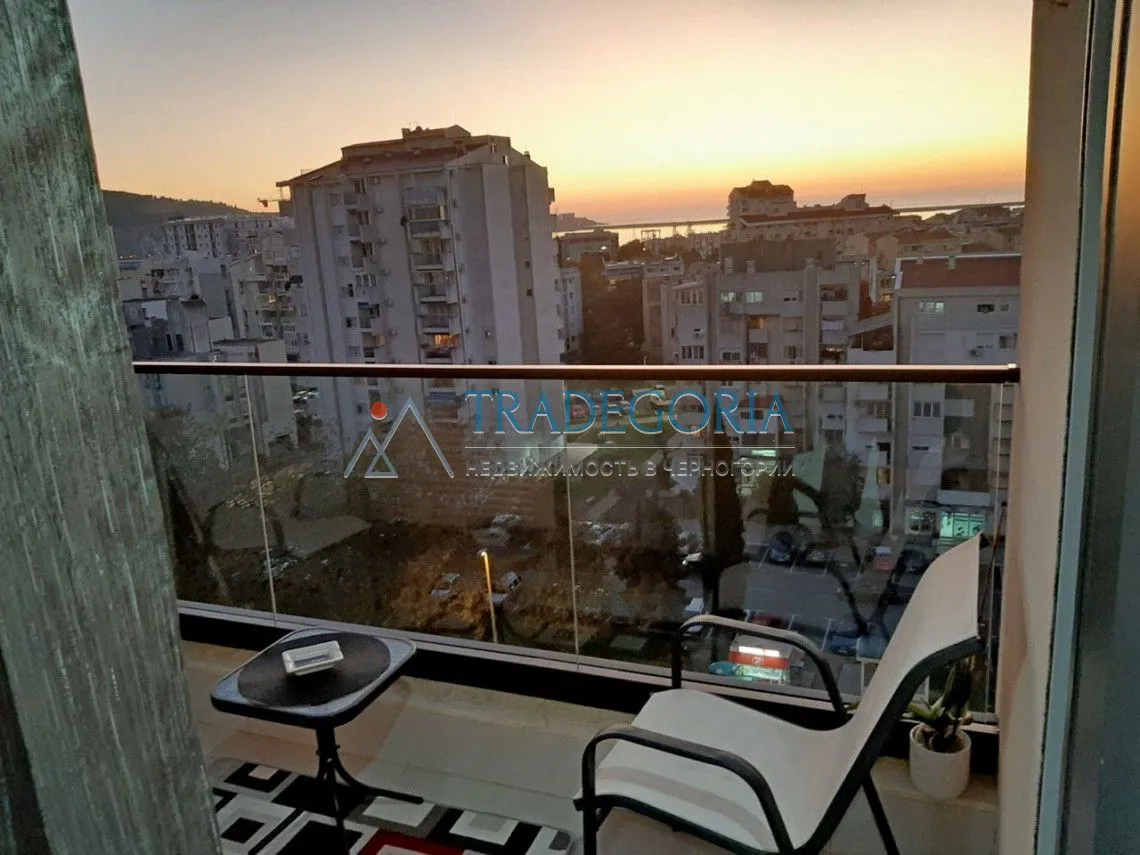 Namješten balkon sa stolom i stolicama i pogledom na grad.