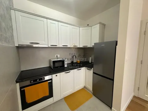 Moderna kuhinja sa bijelim elementima i tamnim frižiderom. - image 4