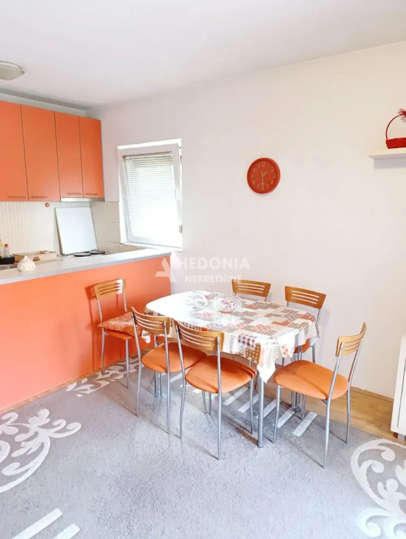 Kitchen with orange cabinets and a dining table with chairs.
