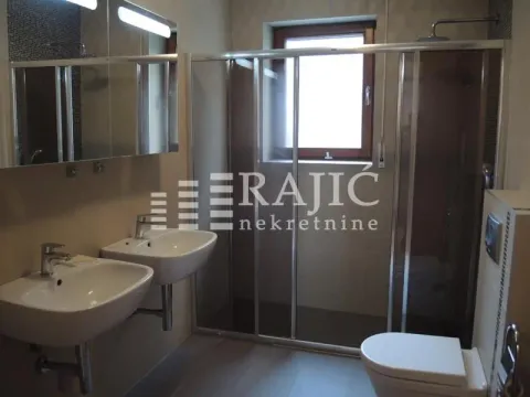 Modern bathroom with two washbasins, a shower cabin, and a toilet. - image 13