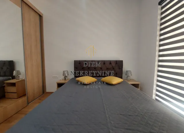 Moderna spavaća soba sa bračnim krevetom, plakarom i noćnim stočićima.