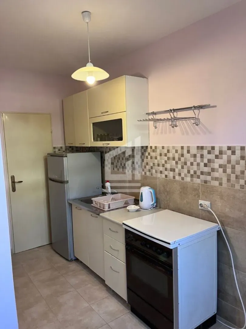 Smaller kitchen with cabinets, refrigerator and stove.