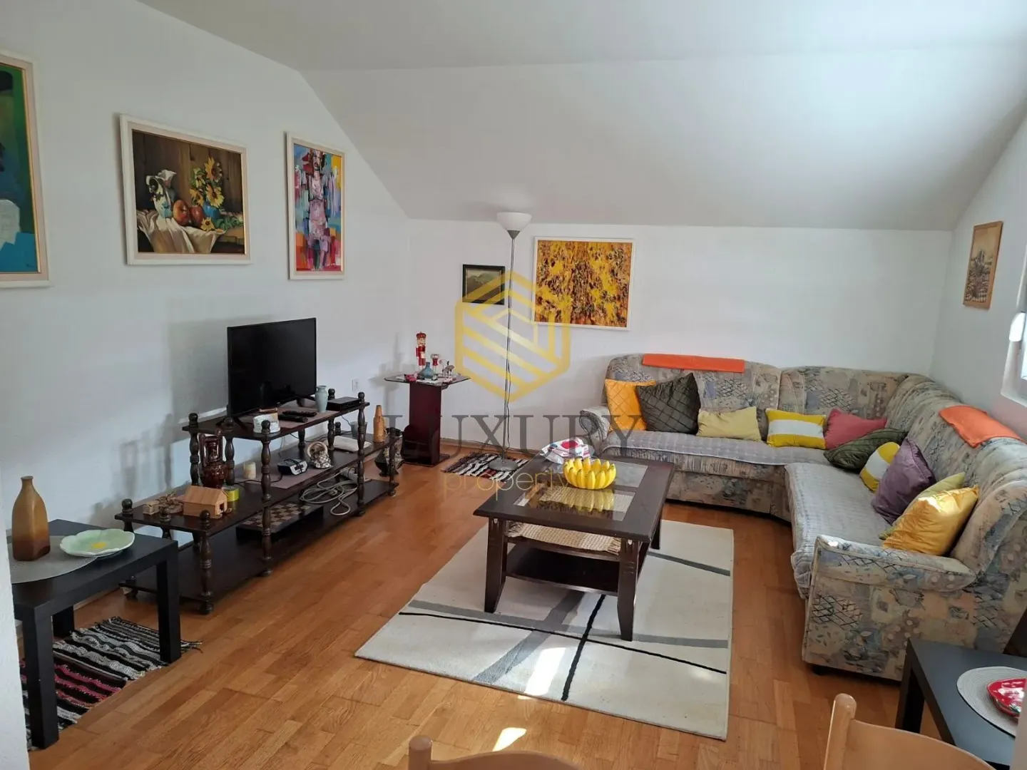 Spacious and bright living room with a sofa set and a TV stand.