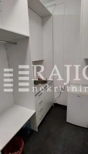 Small kitchen with a sink, units, and a small refrigerator.
