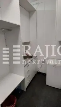 Small kitchen with a sink, units, and a small refrigerator. - image 5