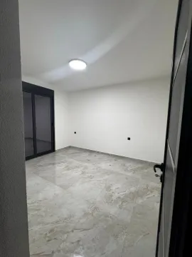 Empty room with ceramic floor tiles and balcony doors. - image 15
