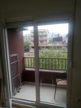 View of the balcony and surrounding buildings through the balcony door. - image 13