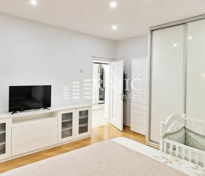 Furnished bedroom with a bed, wardrobe, and television. - image 9