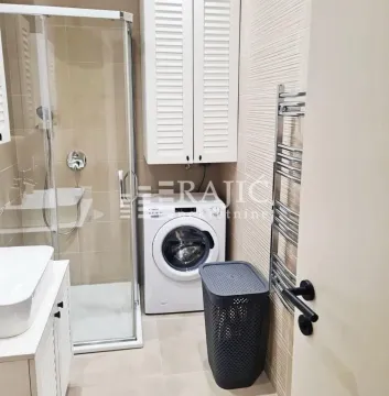 Modernly equipped bathroom with a shower cabin, washbasin, and washing machine. - image 9