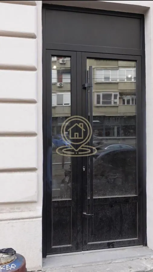 Entrance door of the building with a black metal frame.
