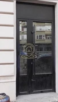Entrance door of the building with a black metal frame. - image 8