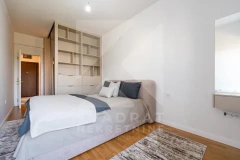 Furnished bedroom with a double bed, built-in wardrobe, and white walls. - image 10
