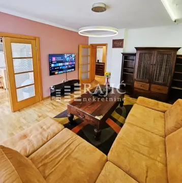 Living room with a sofa set, wooden furniture, and a TV. - image 3