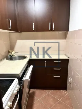 Small kitchen with dark wooden cabinets and ceramic tiles. - image 3