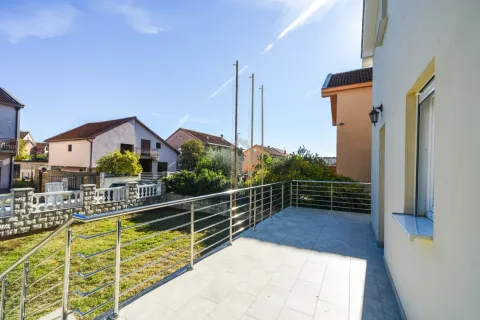 Spacious tiled terrace with a metal railing and a view of the surrounding neighborhood and yard. - image 3