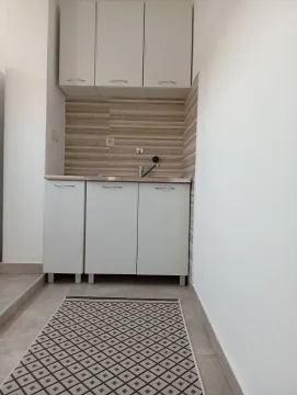 Mala bijela kuhinja sa sudoperom i elementima. - image 6
