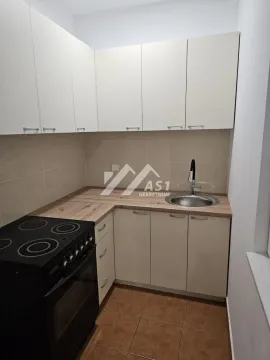 Manja opremljena kuhinja sa belim elementima i šporetom. - image 8