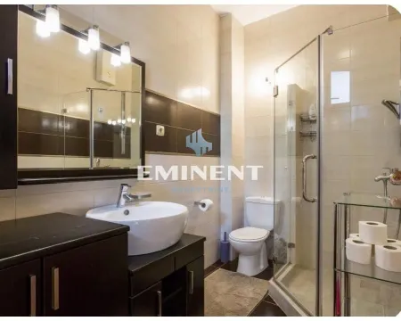 Modern bathroom with a sink, toilet, and shower cabin. - image 9