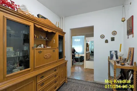 Dnevna soba sa velikim drvenim ormanom i prolazom u drugu prostoriju. - image 8