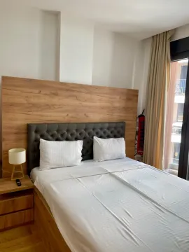 Bright and tidy bedroom with a double bed and wooden headboard. - image 8