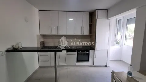 Moderna kuhinja sa bijelim elementima i šankom. - image 3