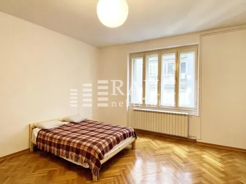 Bright bedroom with a double bed, parquet flooring, and a window. - image 7