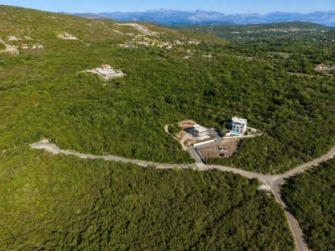 Pogled iz vazduha na kuće okružene zelenilom i prirodom. - image 2