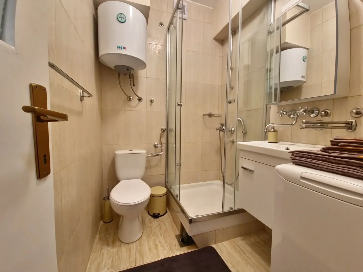 Compact bathroom with a shower cabin, toilet, and washbasin.