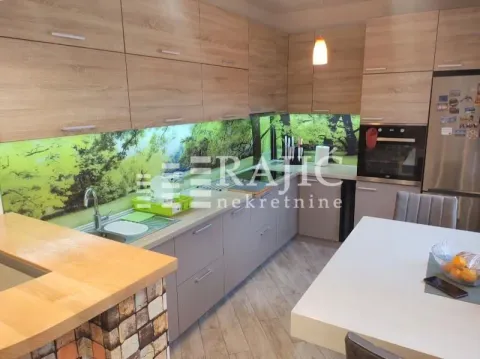 Modern kitchen with wooden cabinetry and a dining table. - image 7