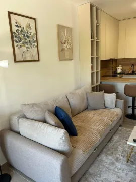Living room with a comfortable sofa and a view of the kitchen in the background. - image 8