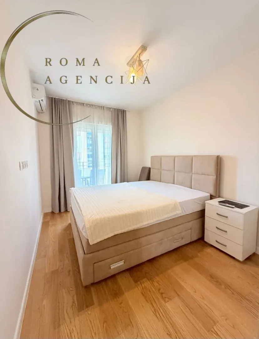 Furnished bedroom with a double bed and a nightstand.