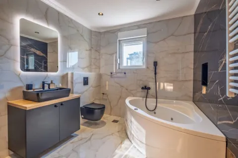 Modern bathroom with a bathtub, washbasin, and black sanitaryware. - image 10