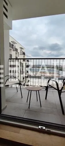 An unfurnished terrace with a small table and two chairs.