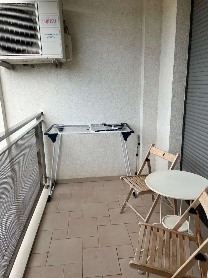 Mali balkon sa sklopivim namještajem i klima uređajem.