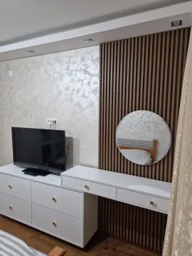 Komoda sa televizorom i toaletni sto sa ogledalom u spavaćoj sobi. - image 2