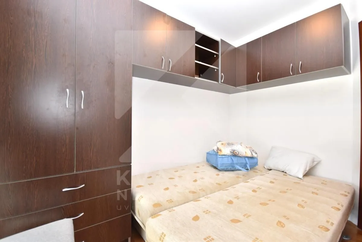 Small bedroom with twin beds and built-in wardrobes.