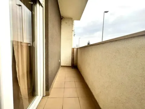 Spacious tiled terrace with balcony doors and a railing. - image 9