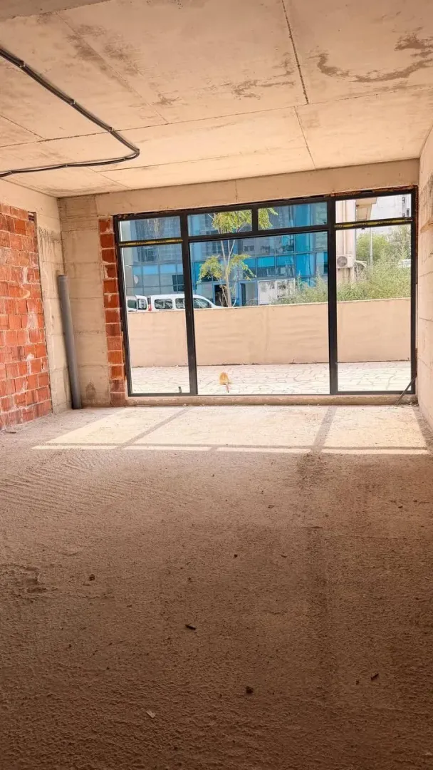 Unfinished room in grey phase with a large window.