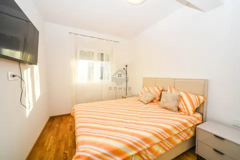 Bedroom with a double bed, window, and wall-mounted TV. - image 6