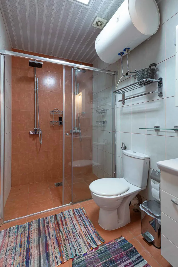 Kupatilo sa tuš kabinom, WC šoljom i bojlerom.